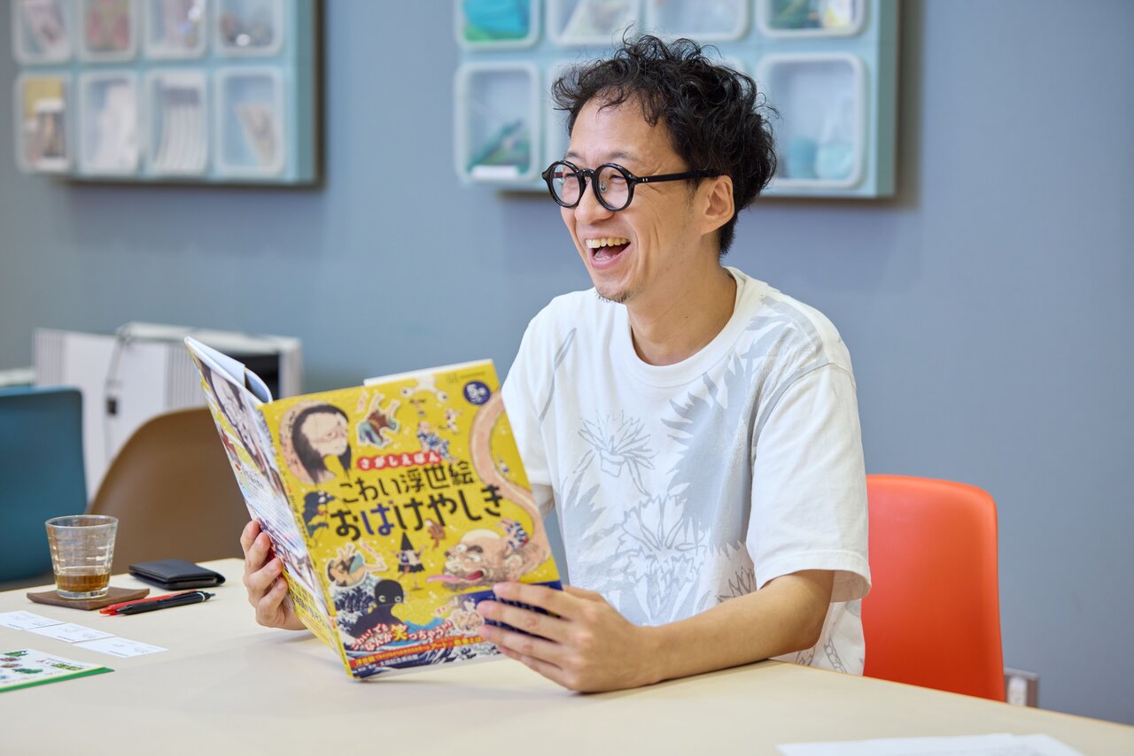 『さがしえほん　こわい浮世絵　おばけやしき』を手に語る小牟田さん